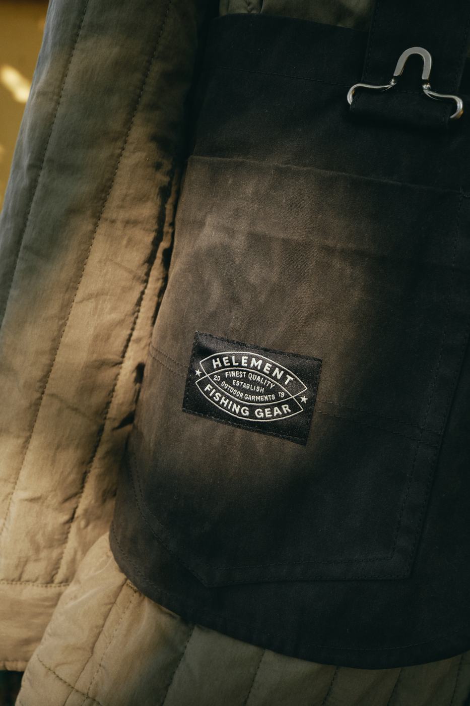 HELEMENT FISHING GEARのラベルが付いたキルティングジャケットのディテール